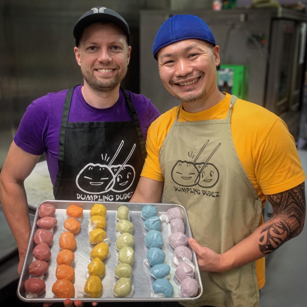 Mike Dorsey and Chih Lin standing in their kitchen with a tray of colorful dumplings