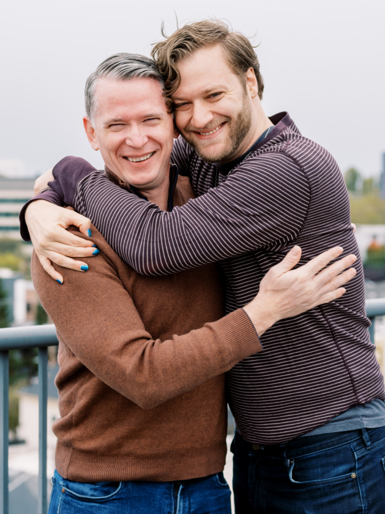 Gayish hosts Mike Johnson and Kyle Getz hugging